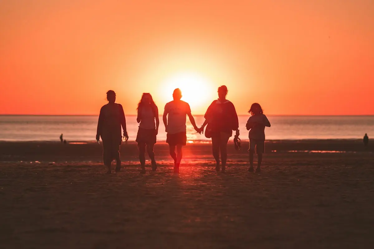 Amigos caminhando na praia ao entardecer
